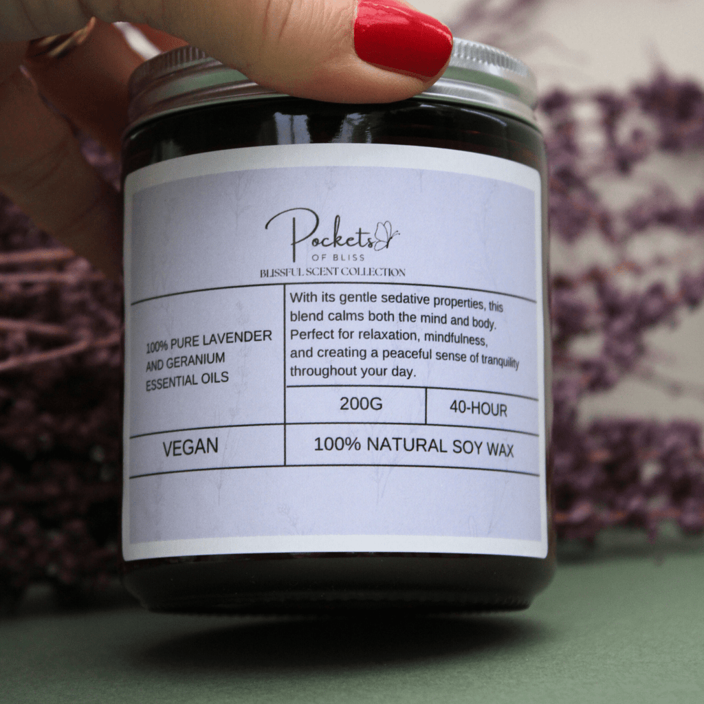 Sian founder of pockets of bliss holding Lavender & Geranium Soy Candle, with red nail varnish and dry lavender in the background. - Pockets of Bliss