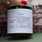 Sian founder of pockets of bliss holding Lavender & Geranium Soy Candle, with red nail varnish and dry lavender in the background. - Pockets of Bliss